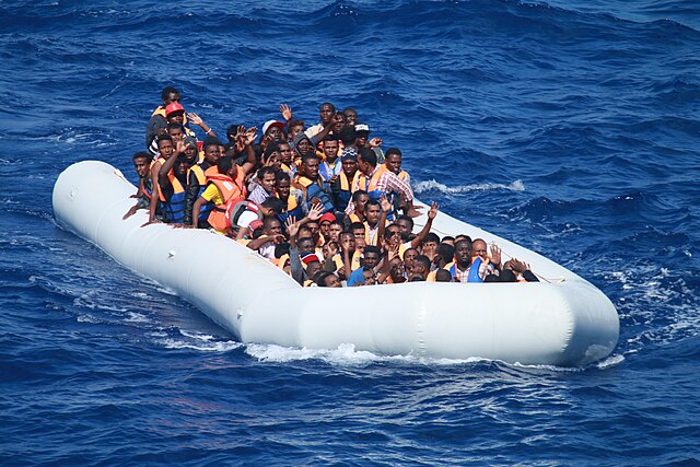 Inflatable_boat_carrying_migrants_approaching_USS_Carney_(DDG-64)_in_the_Mediterranean_160729-N-EU999-004