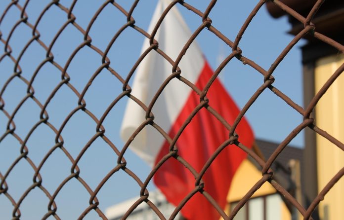 polsk flagg gjerde seriøs-flagg-polsk-polen-korrupsjon-alvorlig-mystisk
