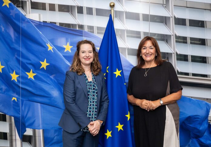 Amy Pope og Dubravka Šuica foran EU-flagg