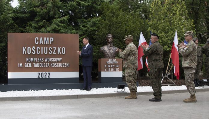 Soldater og offiserer ved skiltet til Camp Kościuszko