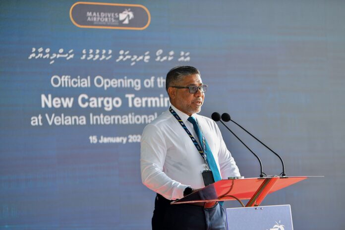 Mann taler ved podiet foran en cargoterminal