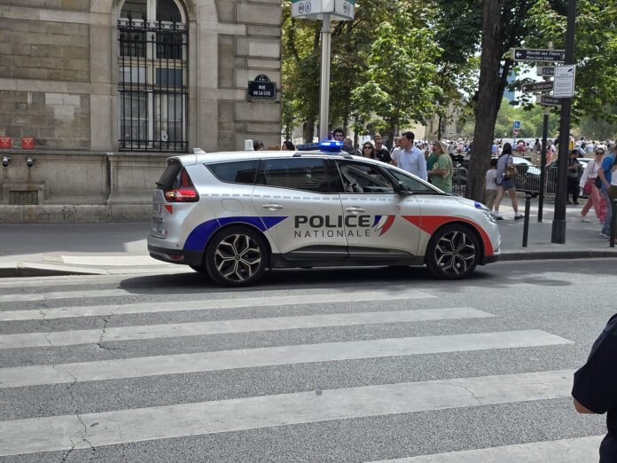 Politibil fra fransk nasjonalpoliti parkert ved en gate i Paris.