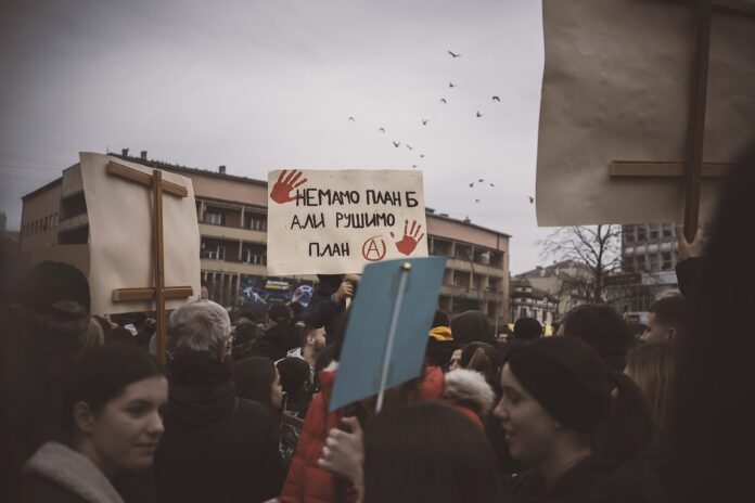 Protestscene med skilt og folk i Serbia